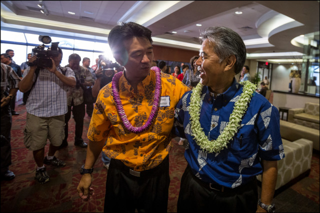 Lt. Gov. Shan Tsutsui and Democratic nominee for Gov. Sen. David Ige walk throughout the media gauntlet as they walk arm and arm into the Democratic Party Unity Breakfast on August 10, 2014