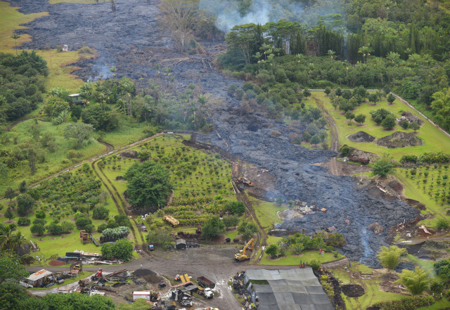 Today's aerial view of molten lava moving from mauka, left of photograph) to rigth,skirting through some structures along a slow approach to Pahoa Village Road. 29 October 2014. photo Cory Lum.