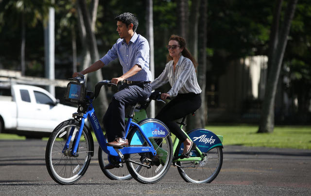 Ben Trevino and Lori McCarney and ride their Bikeshare Hawaii bicycles near Iolani Palace. 7 jan 2015.photograph Cory Lum/Civil Beat