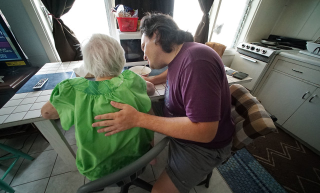 97-year-old Auntie Dorothy gets a pat and rub on her back to get out bubbles from pureed psyllium/vienna sausage. 10 nov 2015. photograph Cory Lum/Civil Beat