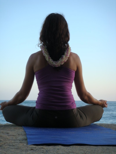 A woman does yoga on the beach in Hawaii, the healthiest state in 2015.