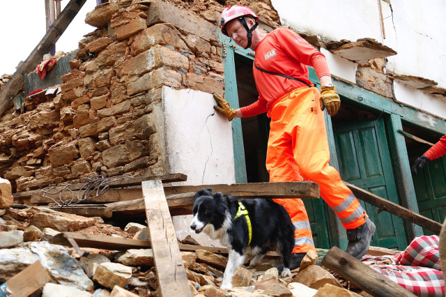 John Ball and his dog Darcy, of the UK International Search and Rescue Team, search for survivors of the April 2015 earthquake north of Kathmandu, Nepal. 