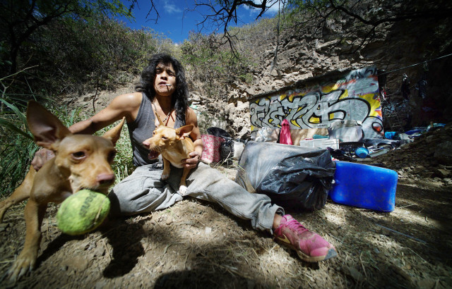 Diamond Head slopes resident Bernadette plays with her dogs named Piranha1 and Piranha2 along the slopes of Diamond Head.