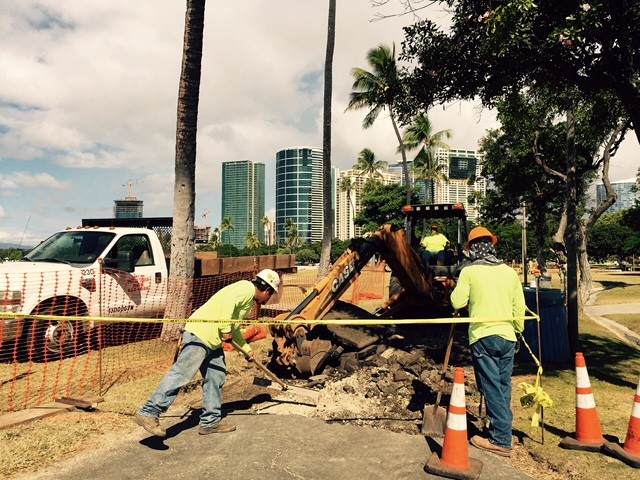 Workers dig up parts of the jogging pathway at Ala Moana Beach Park to be repaved with new asphalt and covered with sealant and painted a red brick color.