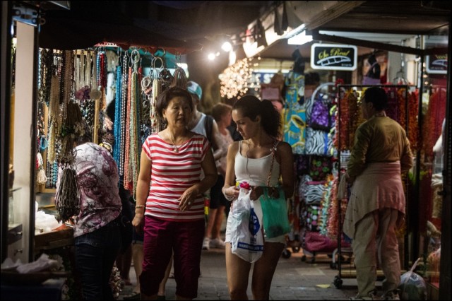 Merchant talks to shopper on the final day of operations at the current International Market Place.