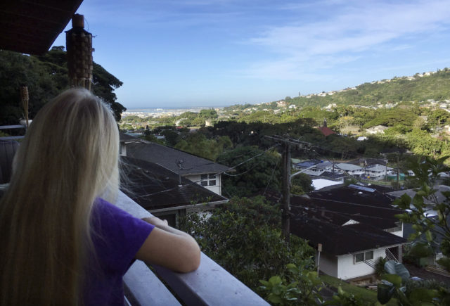 Associated Press correspondent Caleb Jones' 7-year-old daughter looks out toward Pearl Harbor from their home in Honolulu on Sunday, Jan. 14, 2018. Jones was with his daughter at their home on Saturday when an emergency alert warning of a missile strike was sent out to mobile devices across the state. (AP Photo/Caleb Jones)